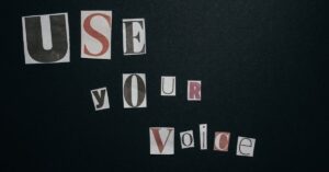 Cutout letters spelling 'Use Your Voice' on a dark background, inspiring activism.