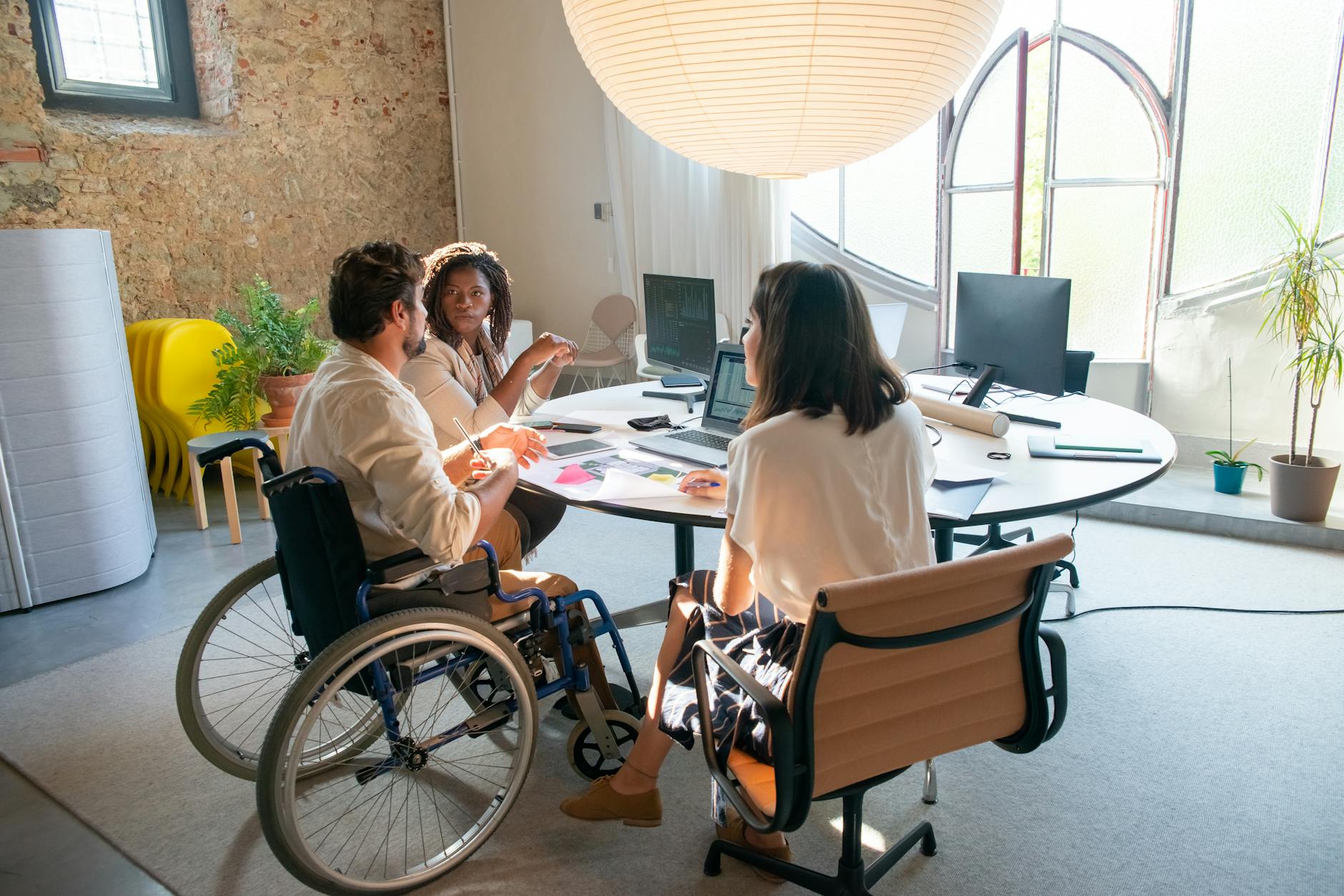 A diverse group of coworkers collaborating in an accessible office environment with a focus on inclusivity.